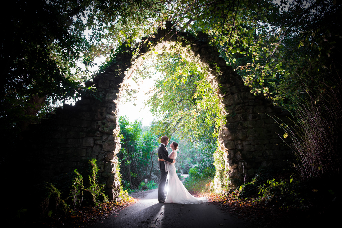 bride and groom under an arch