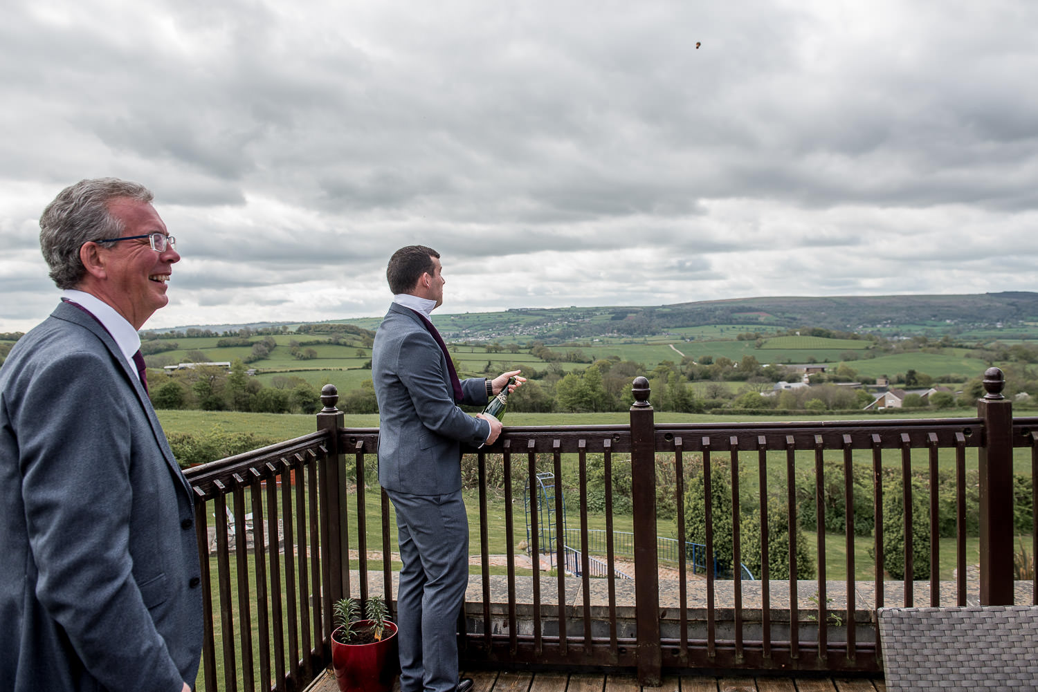 groom opening a bottle of champagne