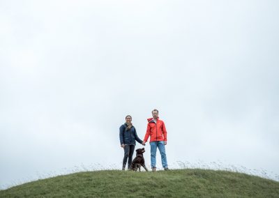 couple and their dog posing on top of cley hill national trust wiltshir