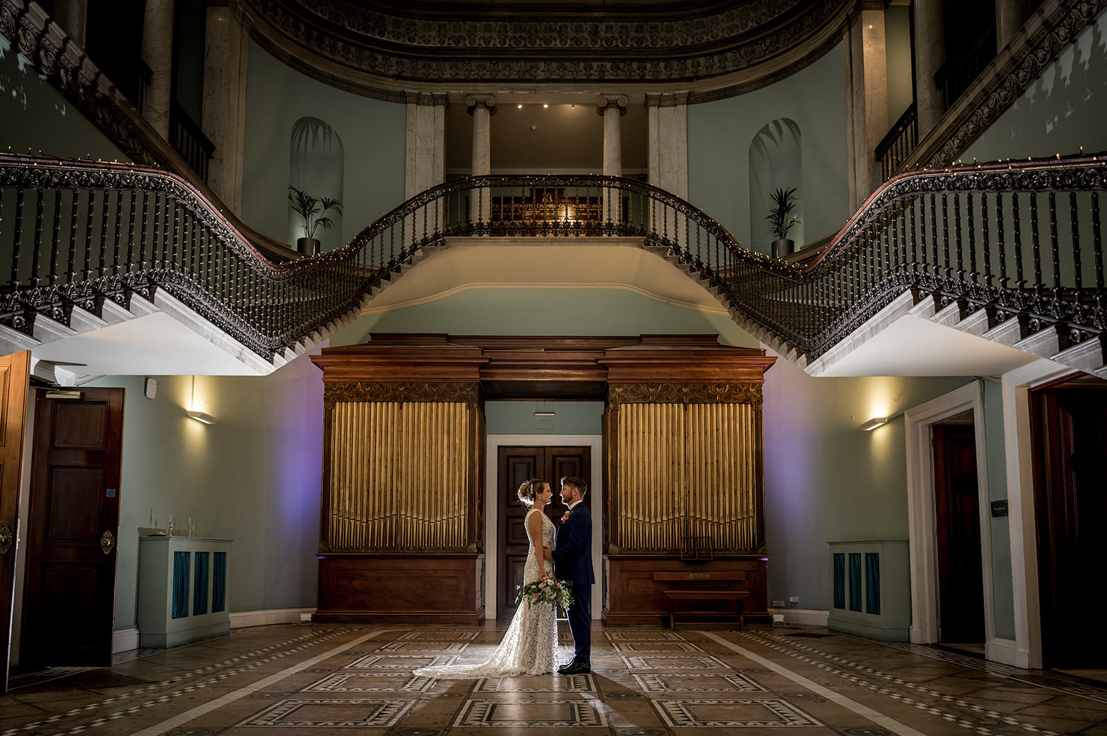 bride and groom posing in the great hall at Leigh Court in Bristol
