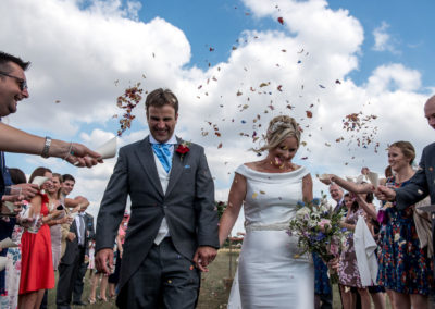 bride and groom walking through confetti, Bath wedding photography