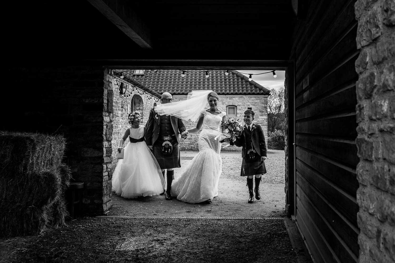 bride and groom walking outside with their children