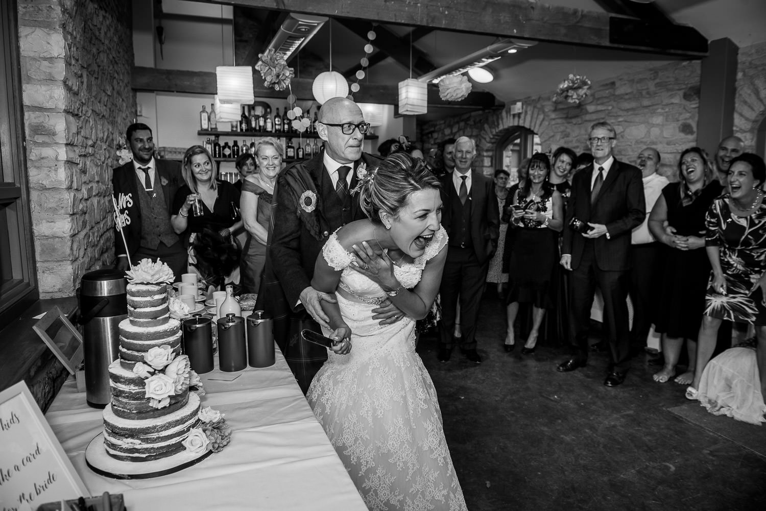 bride and groom having fun cutting the cake