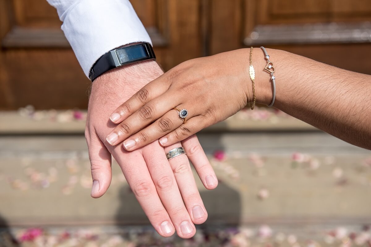 bride and grooms hands with wedding rings